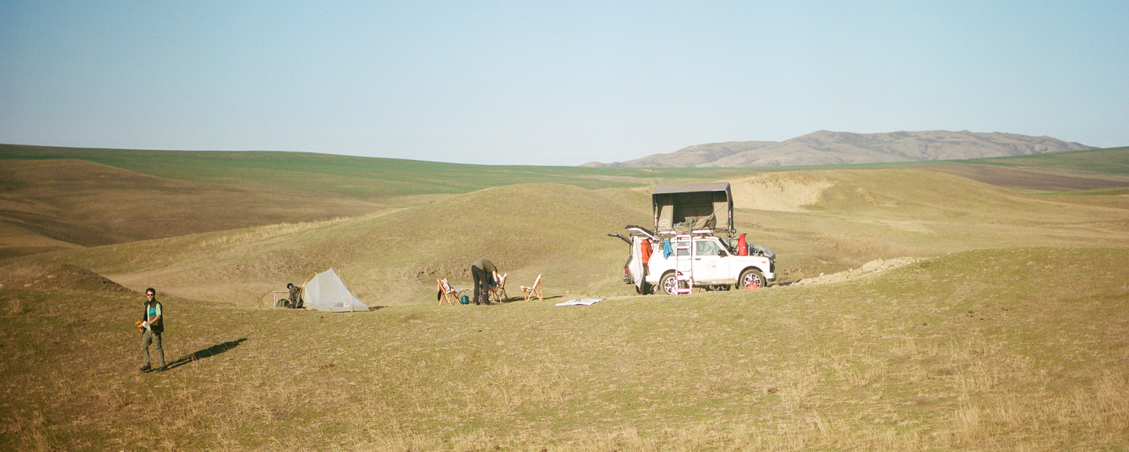 small camp set across rolling open hills