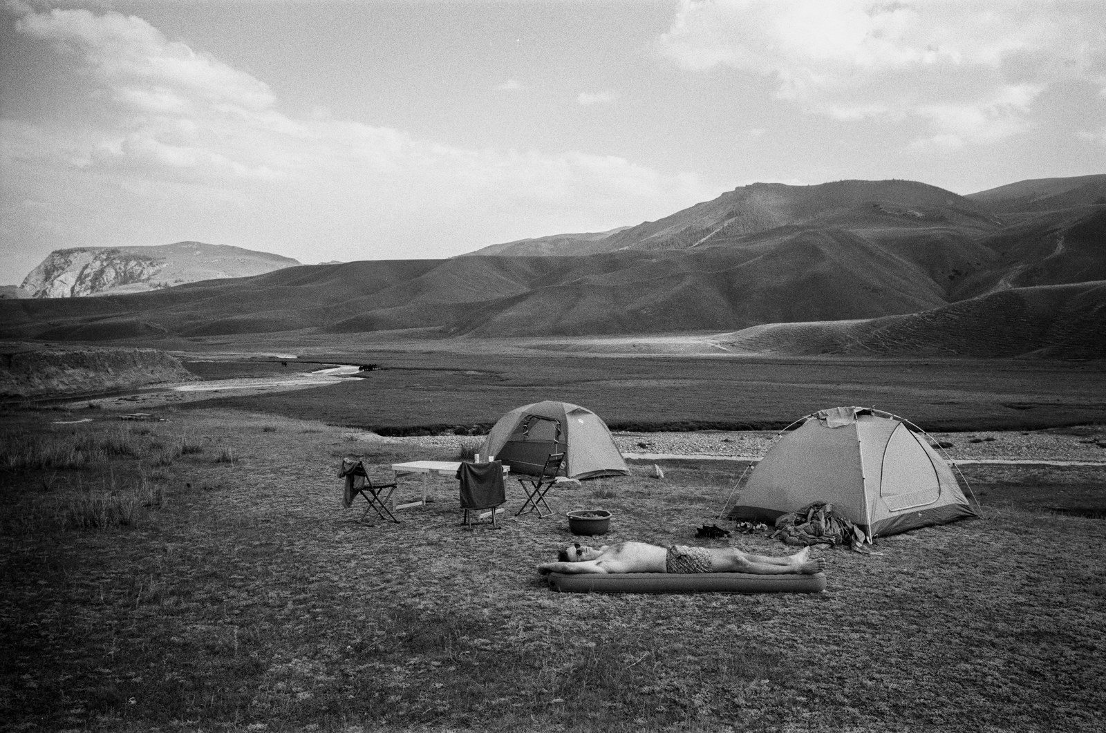 black and white tents set in a wide mountain valley