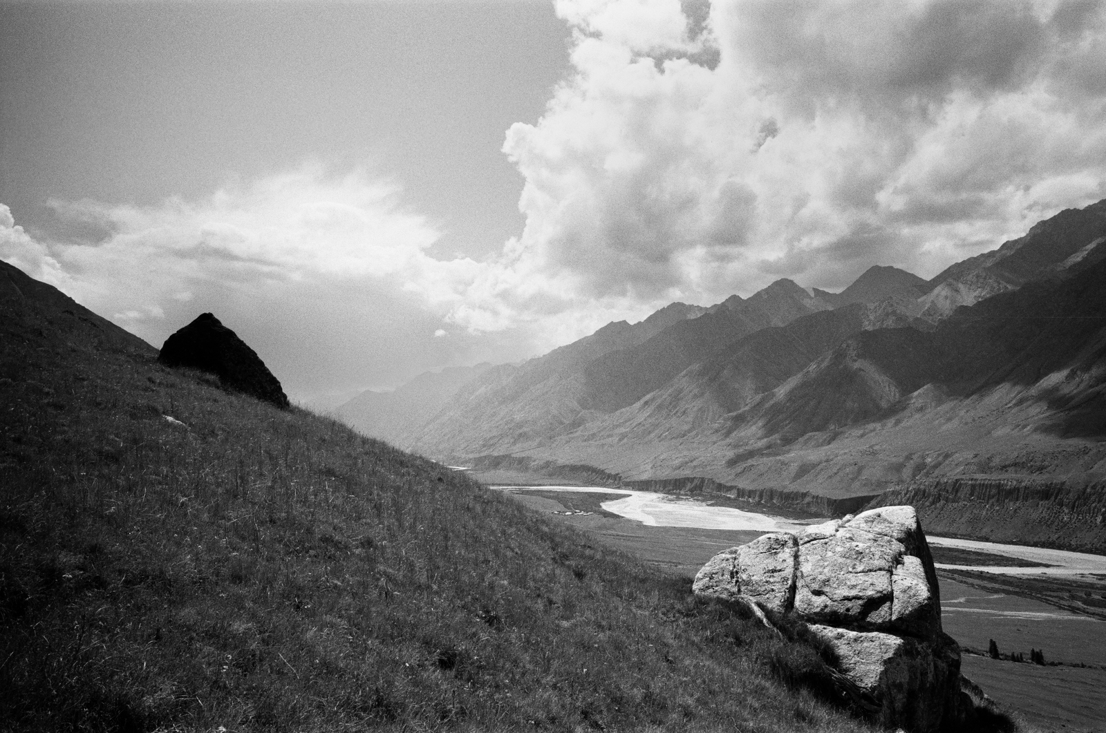 black and white mountain valley under heavy clouds