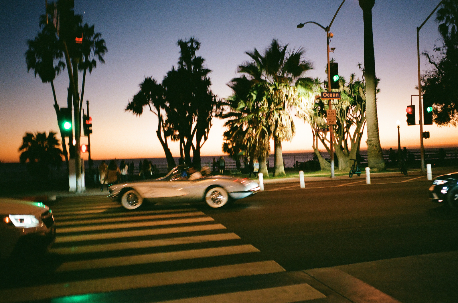 classic car passing palms at night