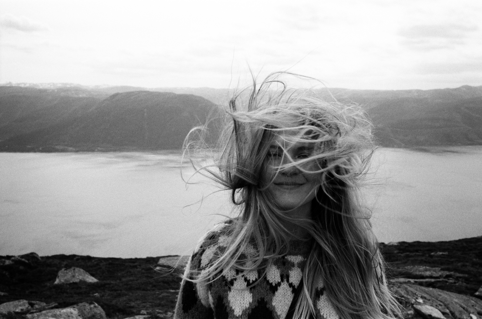 black and white portrait in strong wind beside water