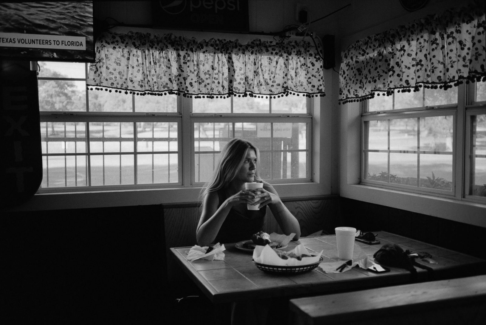 black and white woman seated alone in a diner